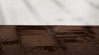 Yağmur damlaları kahverengi masaya düşer.