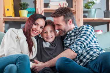 Evde koltukta oturan genç mutlu sevgi dolu bir aile