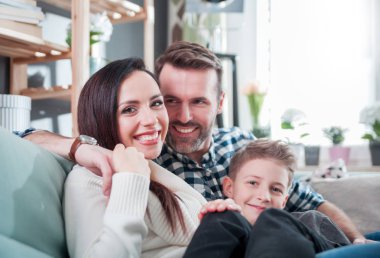 Evde koltukta oturan genç mutlu sevgi dolu bir aile