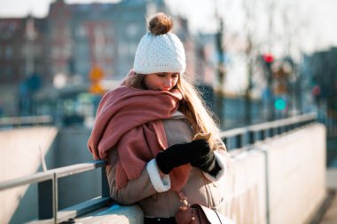 Kış anda caddenin üzerinde hareket eden smartphone kullanan genç kadın