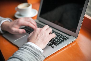 Bir kafede dizüstü klavye yazarak adam görünümü Kapat