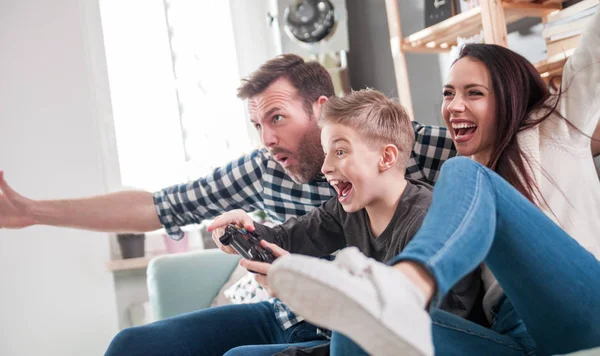 Excited family playing video game on console at home
