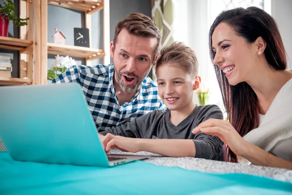 Happy family using laptop computer together at home