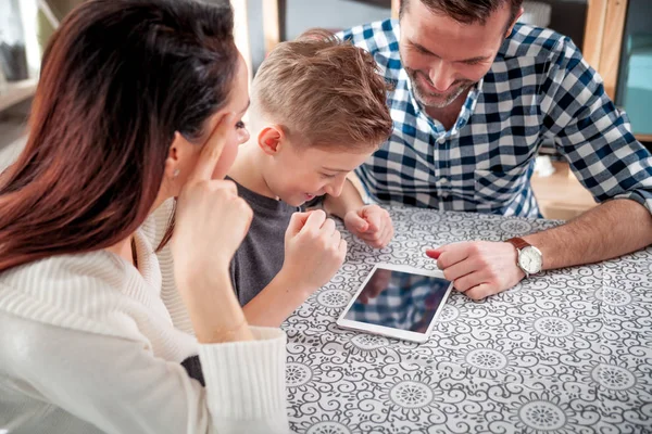 Young family using digital tablet at home