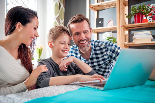 Happy family using laptop computer together at home