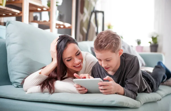 Mãe Filho Deitados Sofá Usando Tablet Digital Casa — Fotografia de Stock