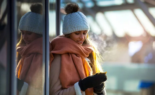 時に冬の街にモバイルのスマート フォンを使用して若い女性 — ストック写真