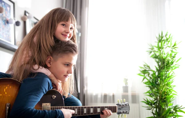 青春期男孩和妹妹在家里玩电吉他 — 图库照片