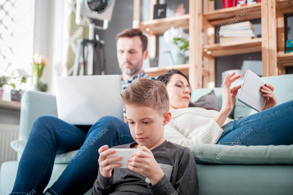 Family using digital devices: laptop, tablet and smartphone at home