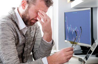 İşyerinde ofiste oturan çok çalışan yorgun işadamı 