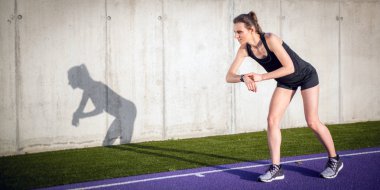 Kadın Stadyumu yolda çalışan ve fitness akıllı saatini ayarlama