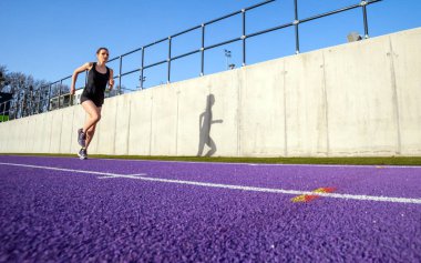 Stadyum yolda çalışan genç atletik kadın 