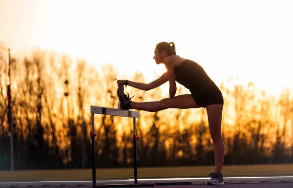 Mujer Atlética Joven Estirándose Pista Atletismo Del Estadio Atardecer — Foto de Stock