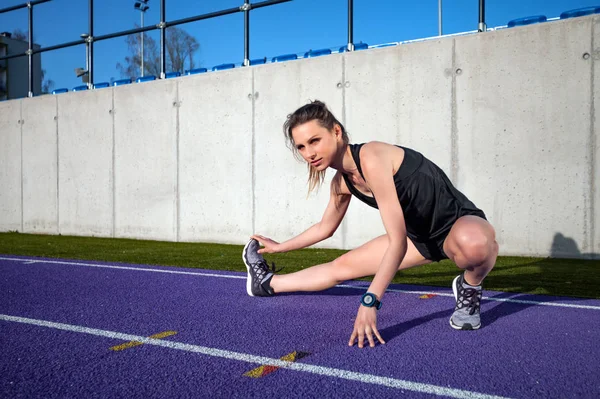 Junge Athletische Frau Dehnt Sich Auf Stadionlaufbahn Vor Dem Joggen — Stockfoto