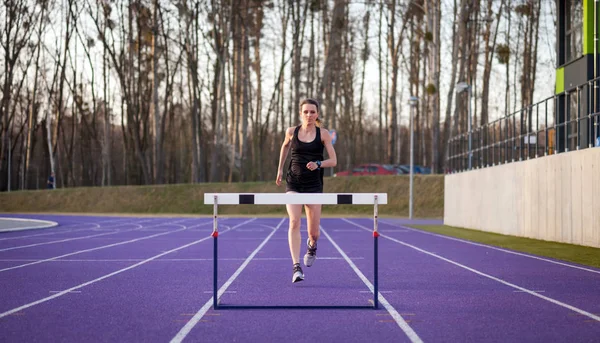 Athletic Woman Running Stadium Track Jumping Hurdle — Stock Photo, Image