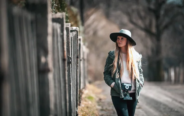 農村地域を歩いてビンテージ カメラを持つ若い女性 — ストック写真