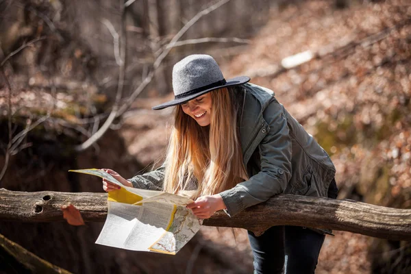 Young tourist woman searching right direction with map in rural area