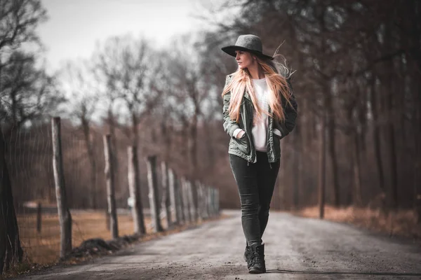 秋の田舎を歩いて帽子の若い女性 — ストック写真