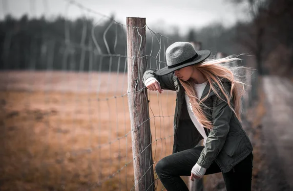 Genç kadın şık şapka kırsal çit poz