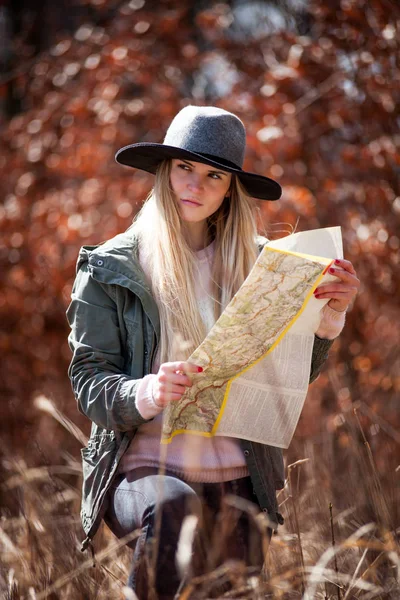 Young tourist woman searching right direction with map in rural area