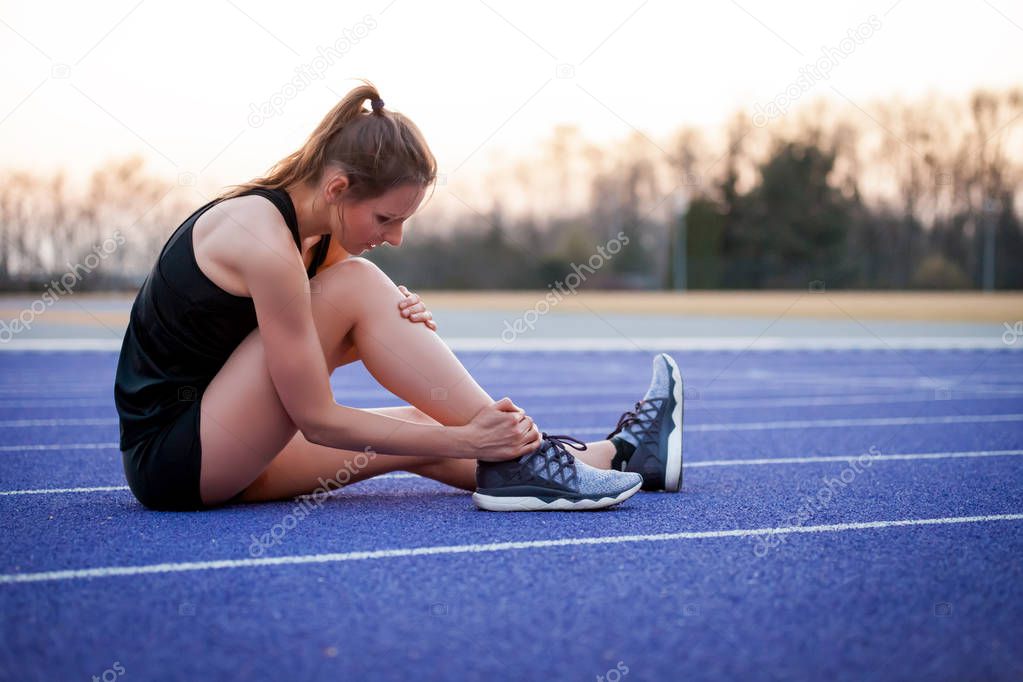 Athlete woman sprained leg on running training