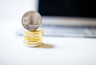 Litecoin ve paralar ile dizüstü bilgisayar arka plan üzerinde yığını