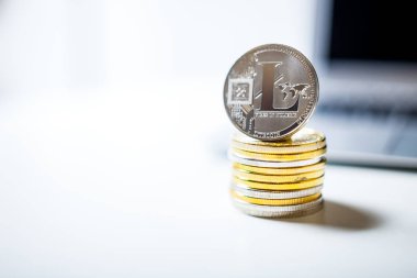 Litecoin ve paralar ile dizüstü bilgisayar arka plan üzerinde yığını