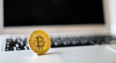 Dizüstü bilgisayar arka plan üzerinde bitcoin sikke görünümünü kapat