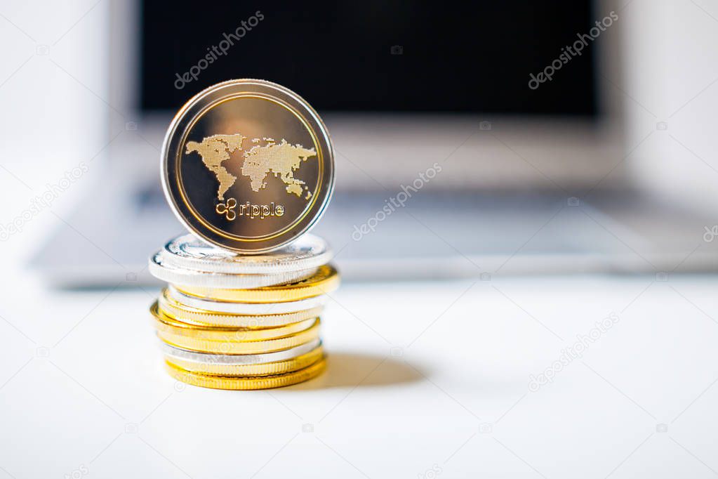 Ripple coin and pile of coins on laptop computer