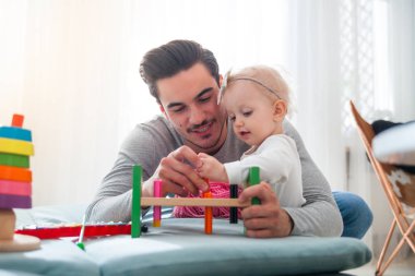 Baba ve kızı evde kanepe üzerinde oyuncaklar ile oynama