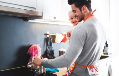 Mutfak ve küçük kızını dikkat çekici baba hazırlanıyor gıda gülümseyen