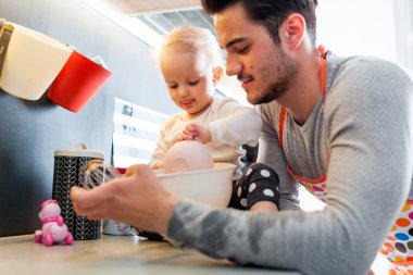 Mutfak ve küçük kızını dikkat çekici baba hazırlanıyor gıda gülümseyen