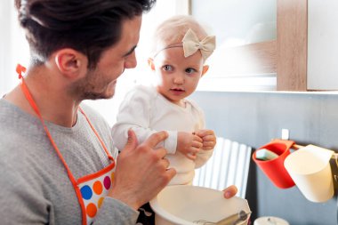 Mutfak ve küçük kızını dikkat çekici baba hazırlanıyor gıda gülümseyen