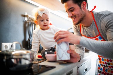 Mutfak ve küçük kızını dikkat çekici baba hazırlanıyor gıda gülümseyen