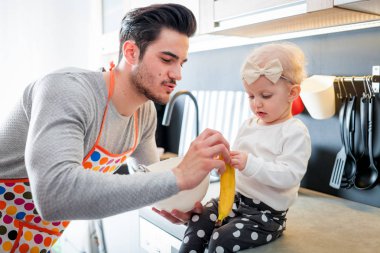 Mutfak ve küçük kızını dikkat çekici baba hazırlanıyor gıda gülümseyen