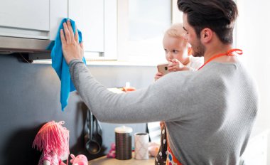 Genç baba küçük kızı yandan mutfak temizlik