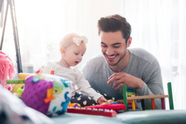 Baba ve kızı evde kanepe üzerinde oyuncaklar ile oynama
