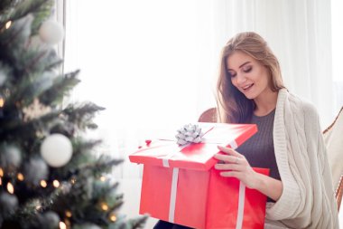 Mutlu sürpriz kadın parlak iç Noel ağacı yakınında Xmas hediye açılış