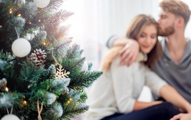 Aşık çift birlikte Noel kutluyor, Xmas ağacının yanında oturan