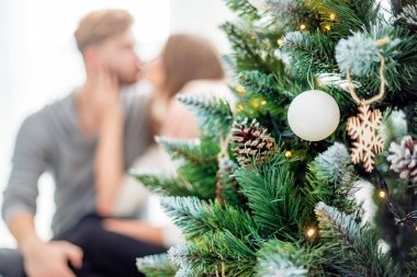 Aşık çift birlikte Noel kutluyor, Xmas ağacının yanında oturan
