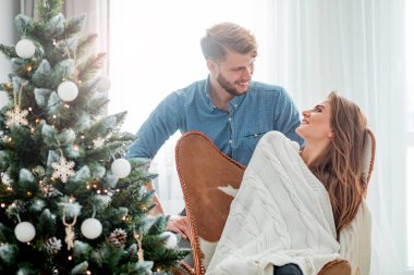 Aşık çift Xmas ağacının yanında evde birlikte Noel kutluyor