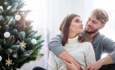 Birlikte Noel kutlayan çift, Xmas ağacının yanında katta oturan