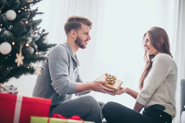 幸せなカップルで愛お祝いクリスマス一緒に家でクリスマスツリーの隣 — ストック写真