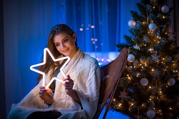 Vrolijke Jonge Vrouw Zittend Naast Kerstboom Het Houden Van Gloeiende — Stockfoto
