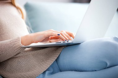 Kadın evde kanepenin üstüne oturan dizüstü online evde çalışan kullanma