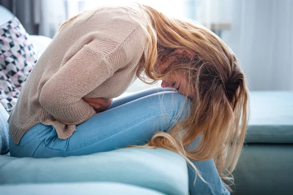 Young Woman Suffering Strong Abdominal Pain While Sitting Sofa Home — Stock Photo, Image