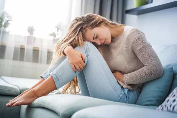 Jovem Que Sofre Forte Dor Abdominal Enquanto Senta Sofá Casa — Fotografia de Stock