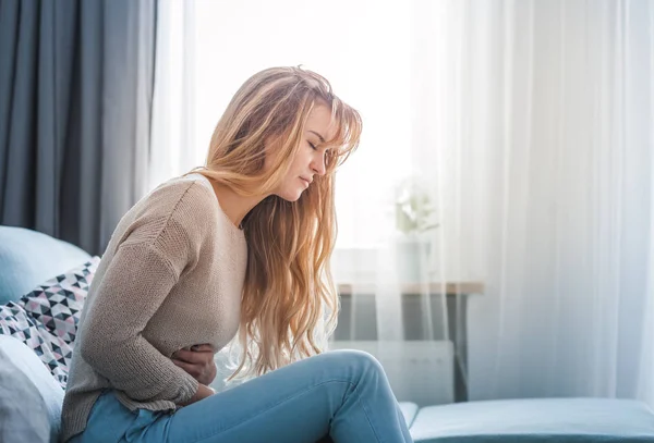 Jovem Que Sofre Forte Dor Abdominal Enquanto Senta Sofá Casa — Fotografia de Stock