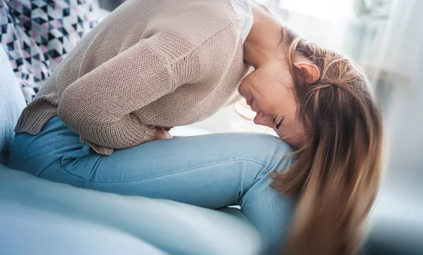 Young Woman Suffering Strong Abdominal Pain While Sitting Sofa Home — Stock Photo, Image