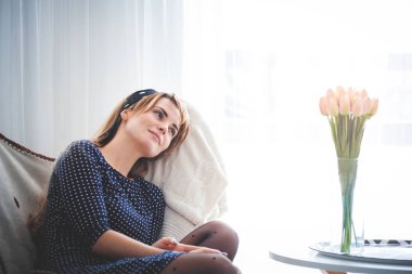 Evde, boş zaman zaman genç kadın üzerinde koltuk hayal ve bir şey hakkında düşünüyor parlak oturma odasında rahatlatıcı